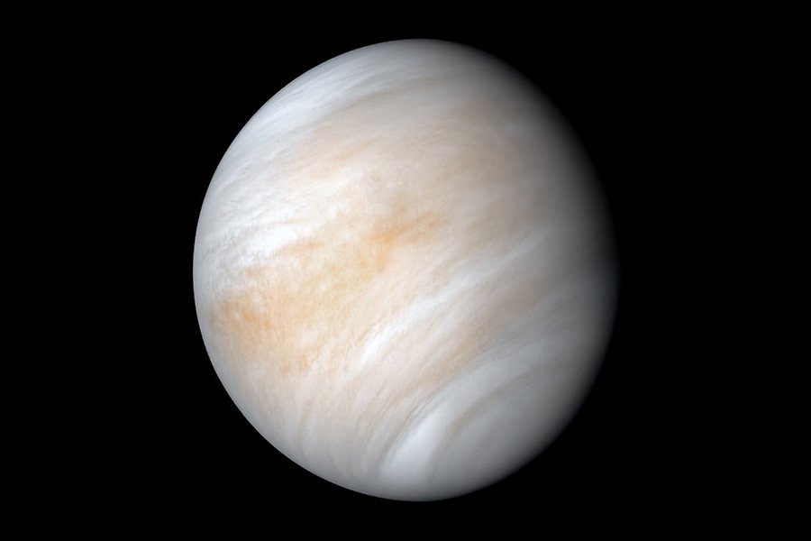 En vacker bild av Venus mot svart bakgrund. Planeten ser vit ut med strimmor av brunt och orange.