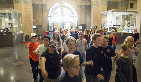 En stor mängd barn strömmmar in genom museets entréhall.