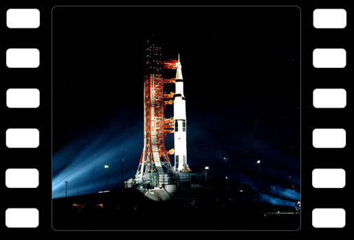 Apollo 14 på startplattan. Det är mörkt, raketen är belyst med strålkastare. 