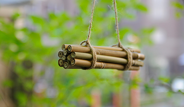 En samling bamburör som är ihopknutna och hänger i ett snöre.